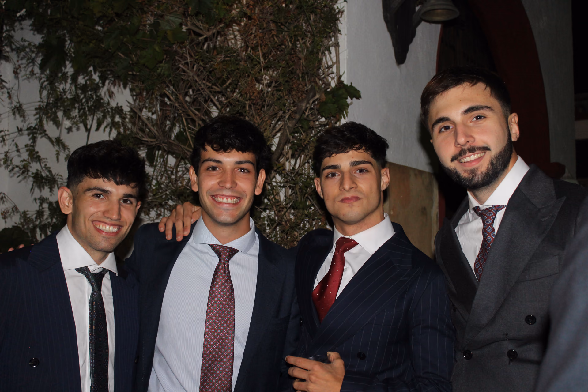 Amigos vestidos de gala posando en un evento